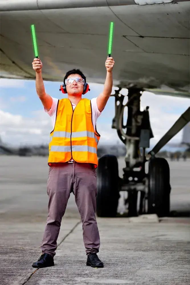 Air traffic controller holding light signs at the airport