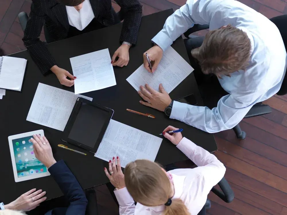 top view of business people group on meeting, working in modern bright office indoor with tablet computer